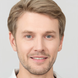 Joyful white young-adult male with short  brown hair and grey eyes