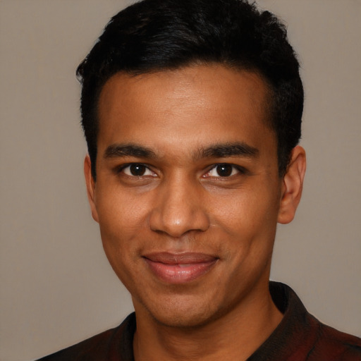 Joyful black young-adult male with short  black hair and brown eyes