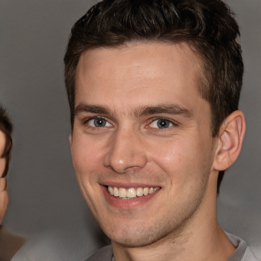 Joyful white young-adult male with short  brown hair and brown eyes