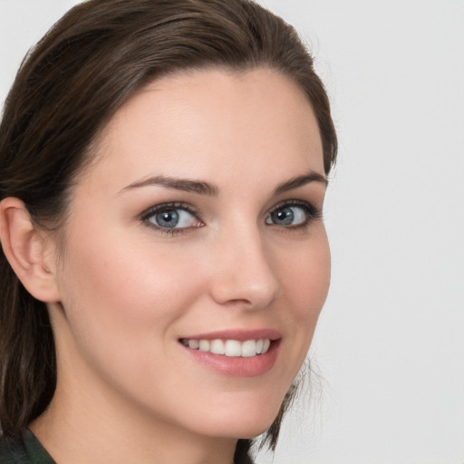 Joyful white young-adult female with medium  brown hair and grey eyes