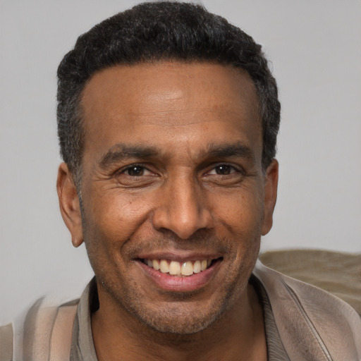 Joyful black adult male with short  black hair and brown eyes