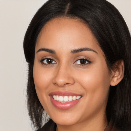 Joyful latino young-adult female with long  black hair and brown eyes