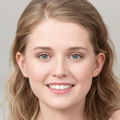 Joyful white young-adult female with medium  brown hair and blue eyes