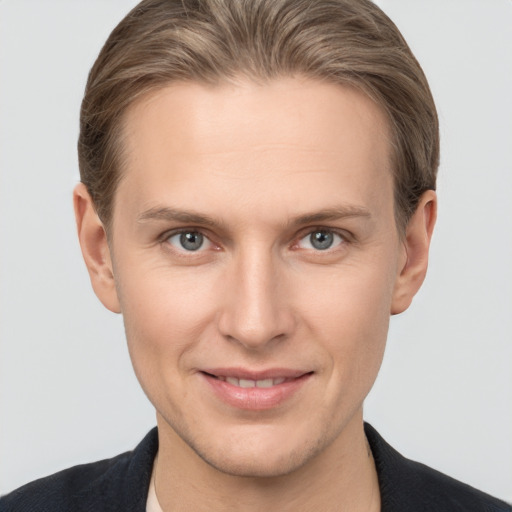 Joyful white young-adult male with short  brown hair and grey eyes