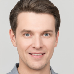 Joyful white young-adult male with short  brown hair and grey eyes