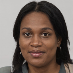 Joyful black adult female with long  brown hair and brown eyes