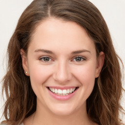 Joyful white young-adult female with long  brown hair and green eyes