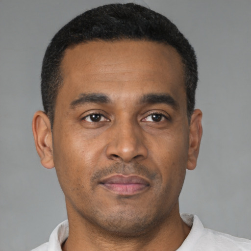 Joyful latino young-adult male with short  brown hair and brown eyes