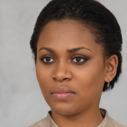 Joyful black young-adult female with short  black hair and brown eyes