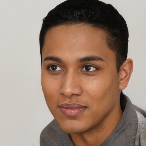 Joyful black young-adult male with short  black hair and brown eyes