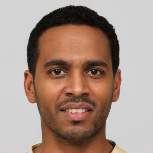 Joyful black young-adult male with short  black hair and brown eyes