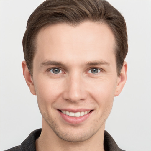 Joyful white young-adult male with short  brown hair and grey eyes