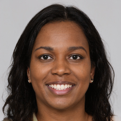 Joyful black young-adult female with long  brown hair and brown eyes