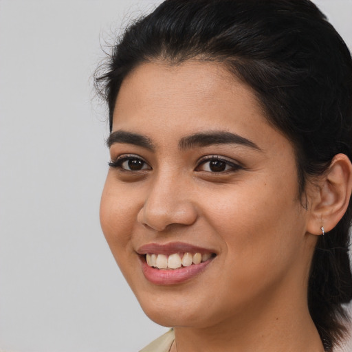 Joyful latino young-adult female with long  brown hair and brown eyes