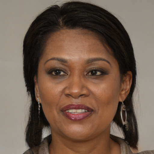 Joyful latino adult female with medium  brown hair and brown eyes