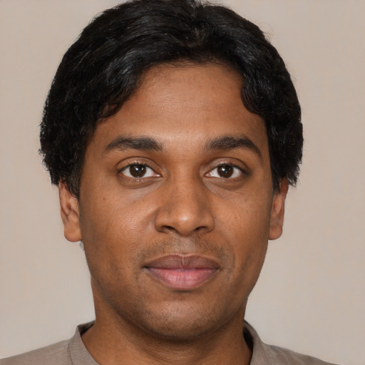Joyful black young-adult male with short  black hair and brown eyes