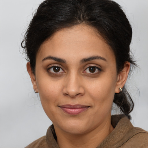 Joyful latino young-adult female with medium  brown hair and brown eyes