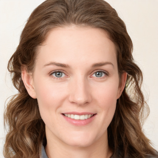 Joyful white young-adult female with long  brown hair and blue eyes