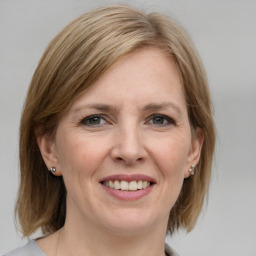 Joyful white adult female with medium  brown hair and grey eyes