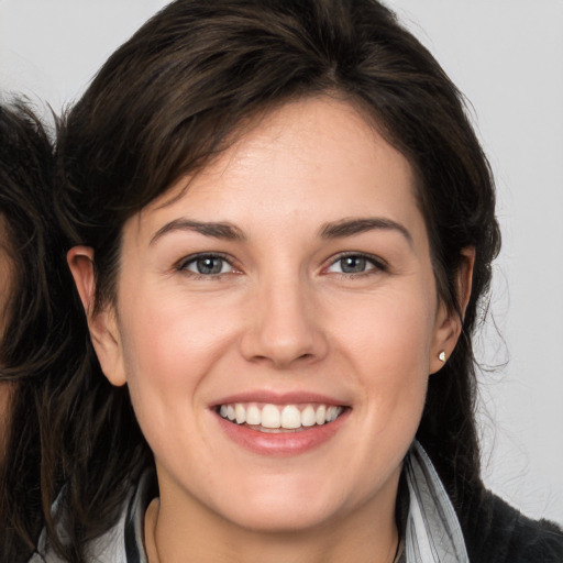 Joyful white young-adult female with long  brown hair and brown eyes