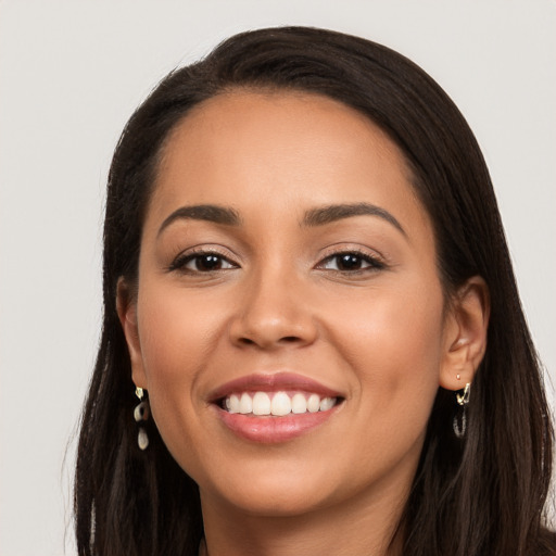 Joyful latino young-adult female with long  brown hair and brown eyes