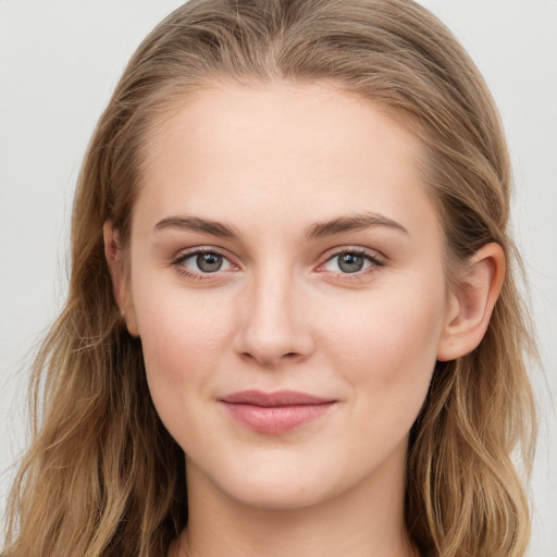 Joyful white young-adult female with long  brown hair and blue eyes