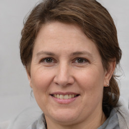 Joyful white adult female with medium  brown hair and grey eyes