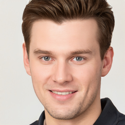 Joyful white young-adult male with short  brown hair and grey eyes