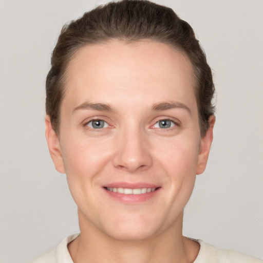 Joyful white young-adult female with short  brown hair and grey eyes