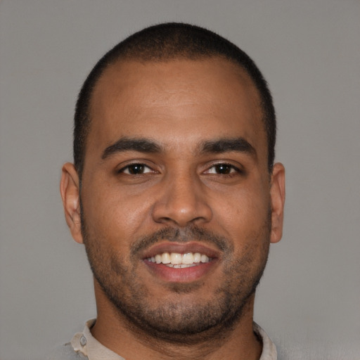 Joyful black young-adult male with short  brown hair and brown eyes