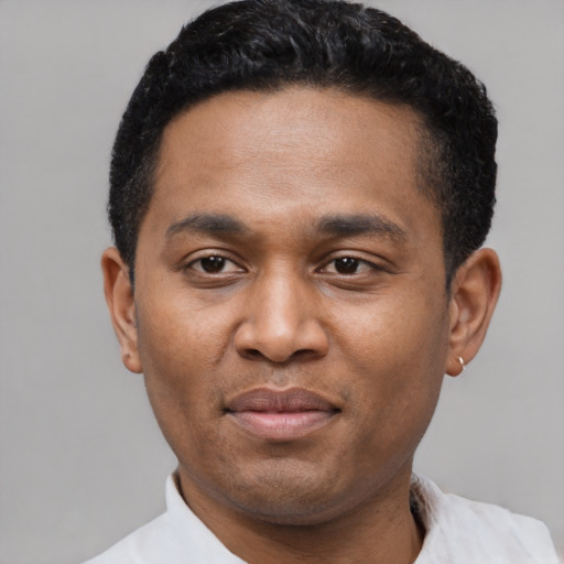 Joyful black young-adult male with short  black hair and brown eyes