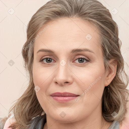 Joyful white young-adult female with medium  brown hair and blue eyes