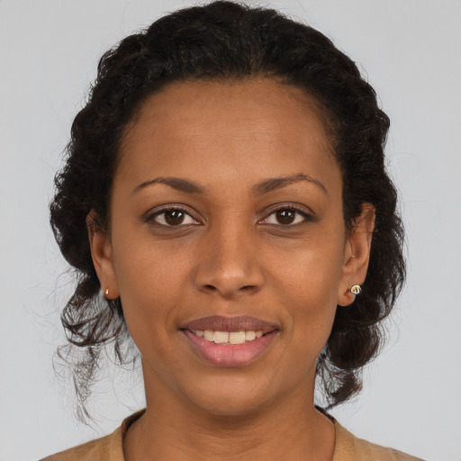 Joyful black young-adult female with medium  brown hair and brown eyes