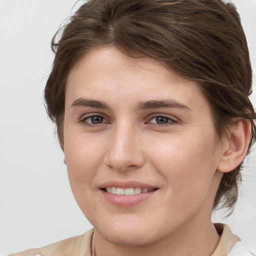 Joyful white young-adult female with medium  brown hair and grey eyes