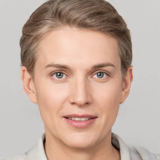 Joyful white young-adult female with short  brown hair and grey eyes