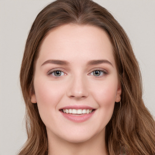 Joyful white young-adult female with long  brown hair and green eyes