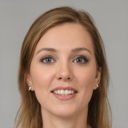 Joyful white young-adult female with long  brown hair and grey eyes