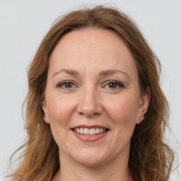 Joyful white adult female with long  brown hair and grey eyes