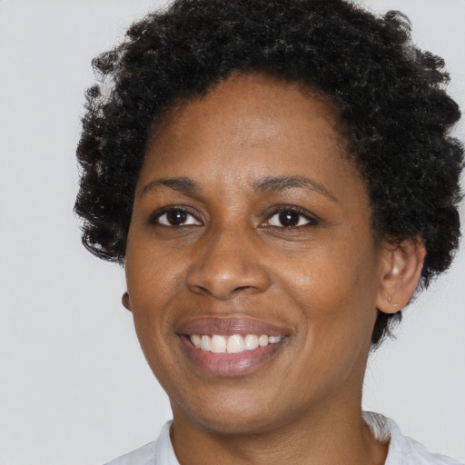 Joyful black adult female with short  brown hair and brown eyes