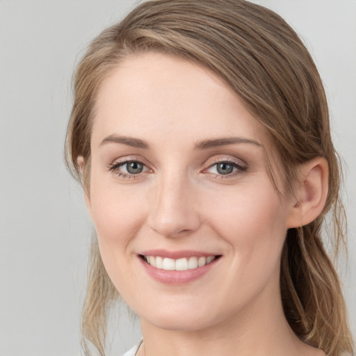 Joyful white young-adult female with medium  brown hair and grey eyes