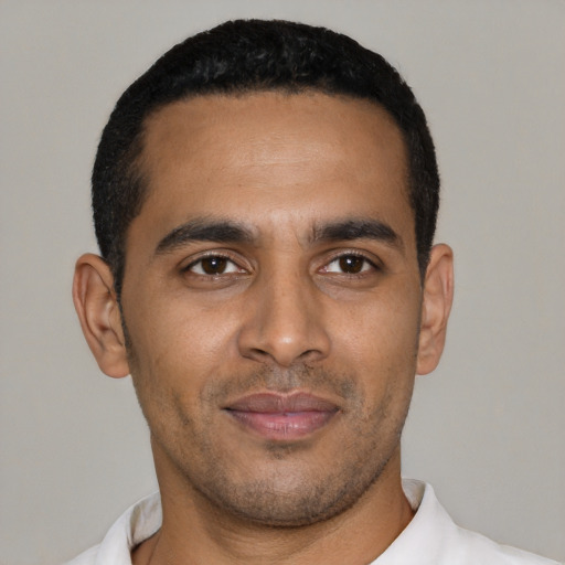 Joyful latino young-adult male with short  black hair and brown eyes