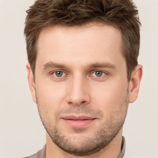 Joyful white young-adult male with short  brown hair and brown eyes