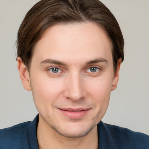 Joyful white young-adult male with short  brown hair and grey eyes