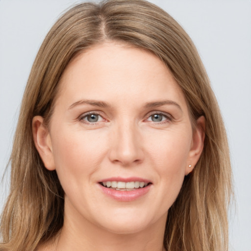 Joyful white young-adult female with long  brown hair and grey eyes