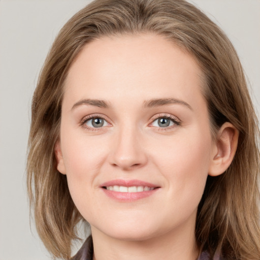 Joyful white young-adult female with long  brown hair and blue eyes