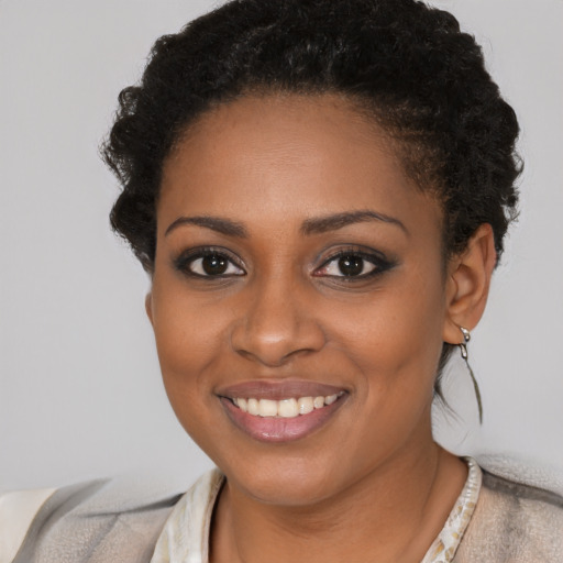 Joyful black young-adult female with short  brown hair and brown eyes