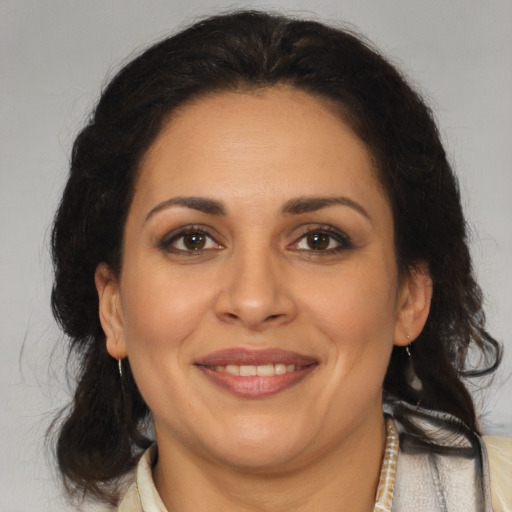 Joyful latino adult female with medium  brown hair and brown eyes