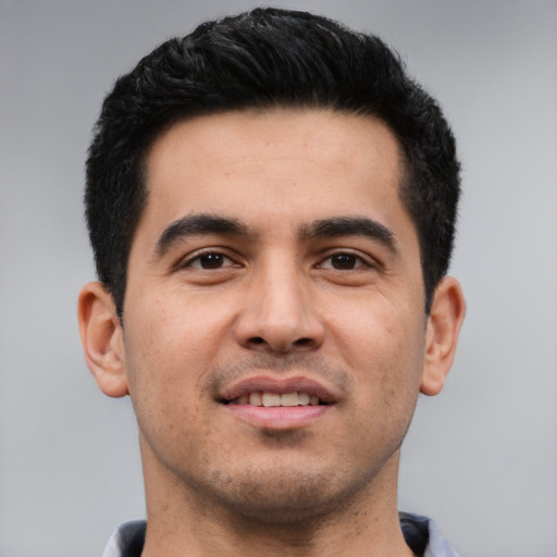 Joyful white young-adult male with short  black hair and brown eyes