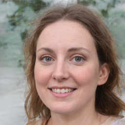 Joyful white adult female with medium  brown hair and green eyes