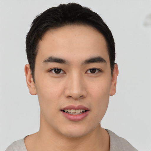 Joyful asian young-adult male with short  black hair and brown eyes